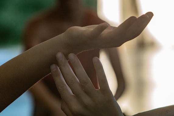 Gentle hands touching during a somatic movement therapy session